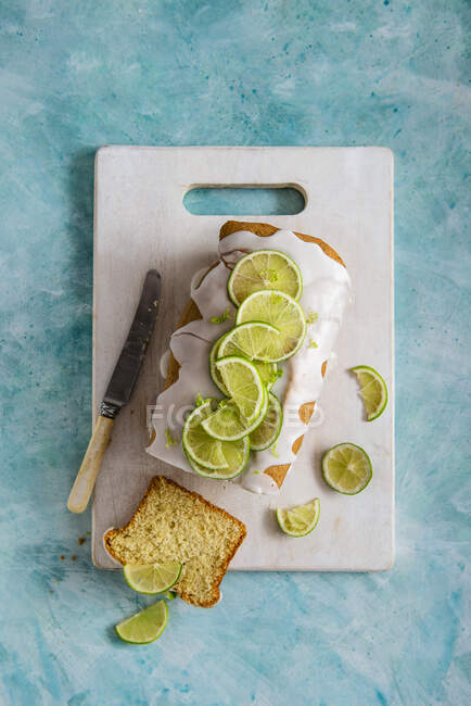 Lime sponge with icing, slice removed — Stock Photo