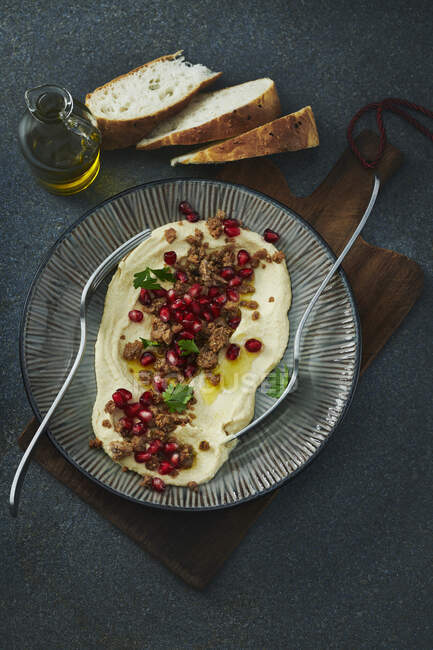 Hummus with pomegranate seeds, minced meat and olive oil — Stock Photo