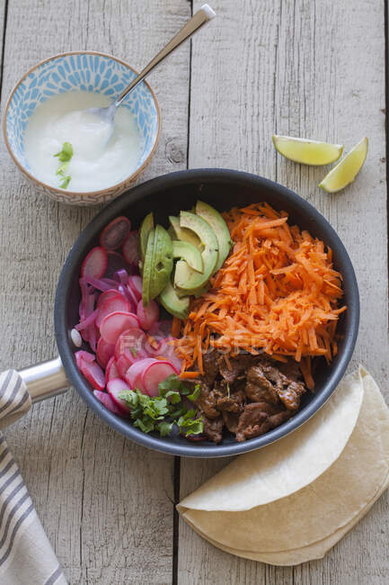 Ingredientes de tacos - zanahoria, aguacate, carne de res, tortillas, lima, crema agria - foto de stock