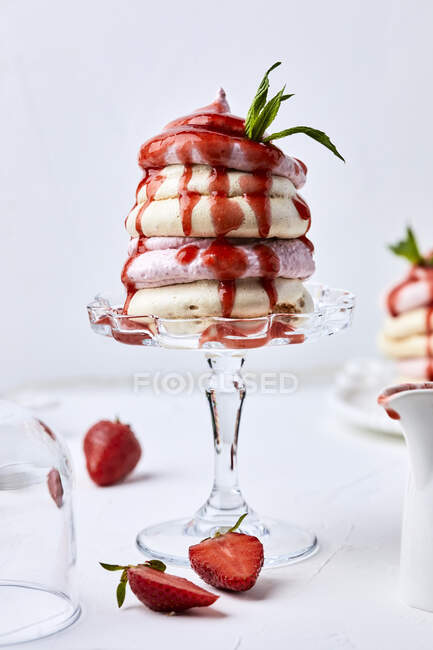 Strawberry pavlova with strawberry sauce on glass stand — Stock Photo