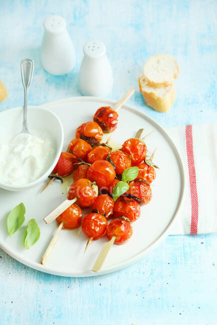 Roasted cherry tomato skewers served with fresh stracciatella — Stock Photo