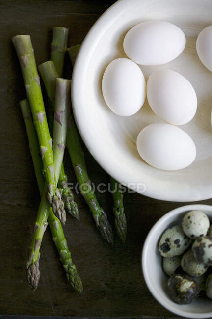 Huevos de gallinas blancas, huevos de codorniz y espárragos bodegones - foto de stock