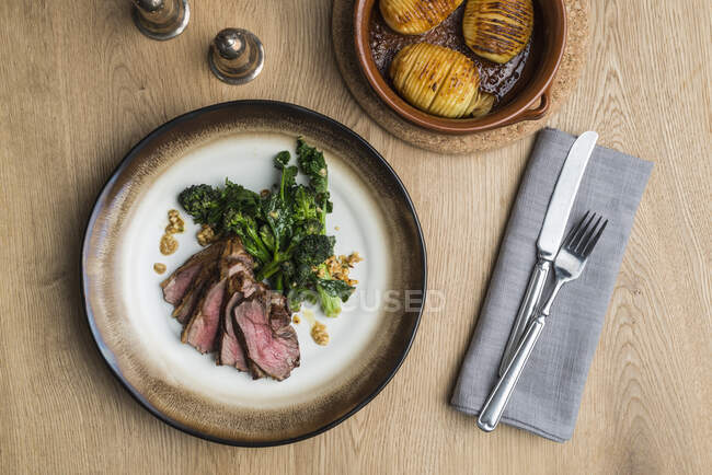 Beef steak with broccolini and hasselback potatoes — Stock Photo
