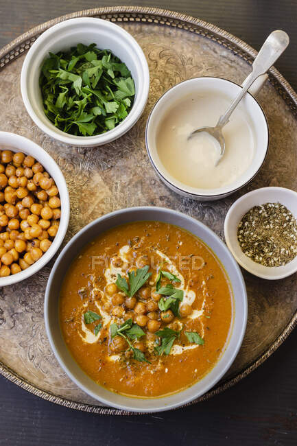 Sopa de cenoura com grão de bico assado, tahini, zaatar e salsa — Fotografia de Stock