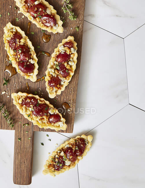 Pan casero horneado con queso y tomates cherry sobre fondo de madera blanca - foto de stock