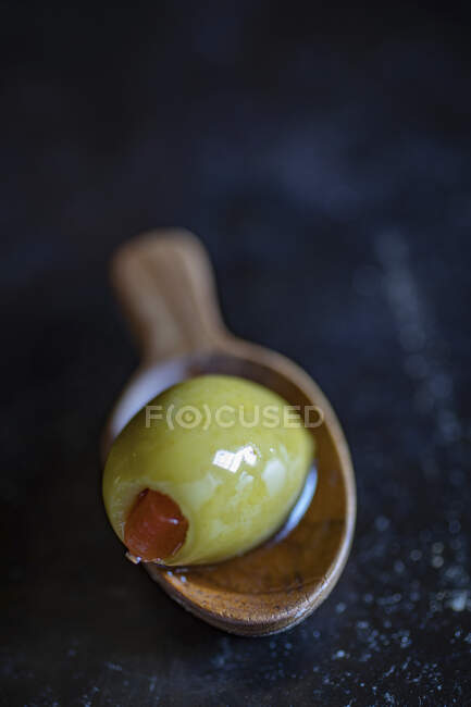 Зеленая оливка на деревянной ложке — стоковое фото