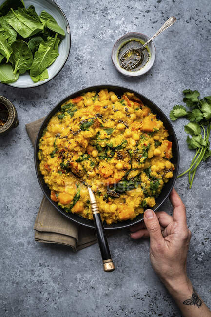 Vegan red lentil, chickpea and squash dahl with spinach in a bowl (India) — Stock Photo