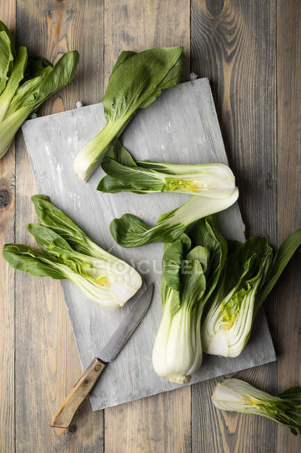 Pak choy on cutting board with knife — Stock Photo