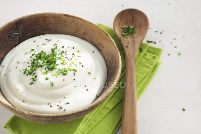 Quark allo yogurt con erba cipollina in una ciotola di legno — Foto stock