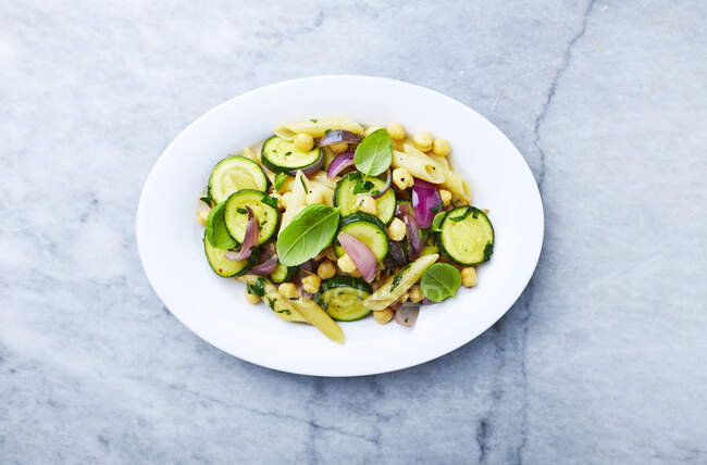 Penne pasta with zucchini, red onion and chickpeas — Stock Photo