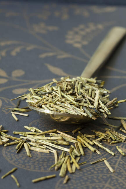 Getrocknete Rosmarinblätter in einem Holzlöffel auf braunem Hintergrund — Stockfoto