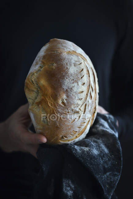 Чоловік тримає в руках оливковий хліб — стокове фото