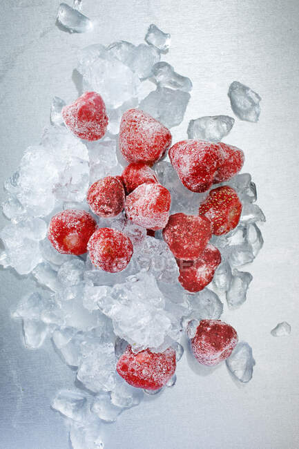 Close-up de deliciosos morangos congelados com cubos de gelo — Fotografia de Stock