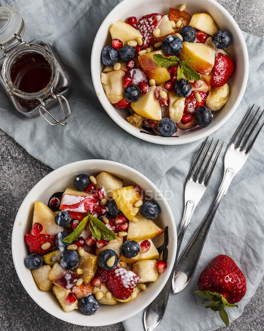 Fruit salad with apples, bananas, strawberries and honey — Stock Photo