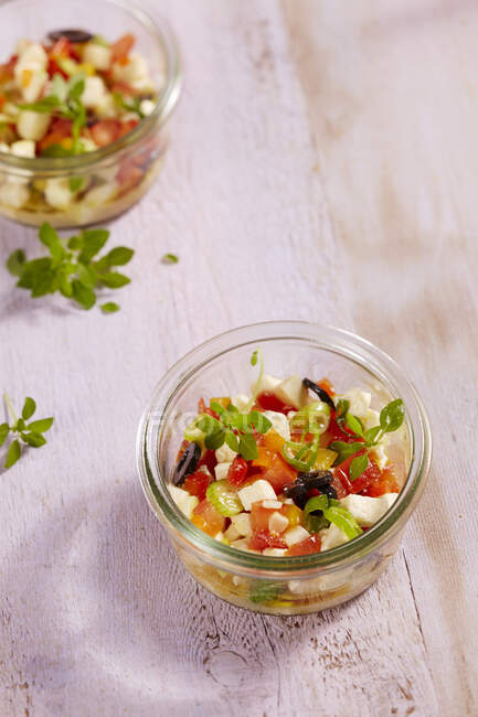Mozzarella-Salat mit Tomaten, Frühlingszwiebeln, Paprika, Oliven und Basilikum im Glas — Stockfoto
