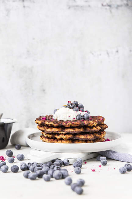 A stack of pumpkin waffle with blueberries and yoghurt — Stock Photo