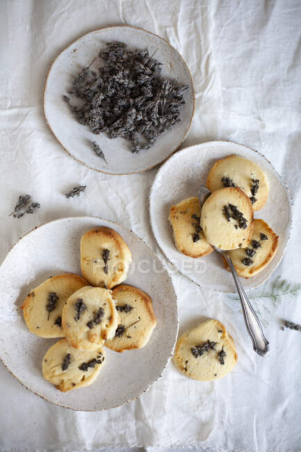 Biscoitos de lavanda de manteiga em pratos com flores de lavanda secas — Fotografia de Stock