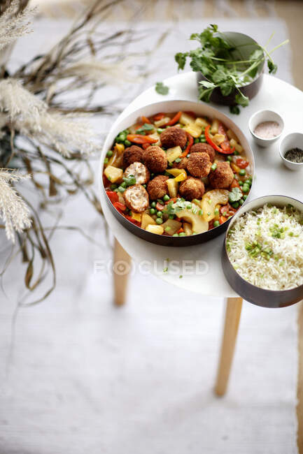 Fried seafood balls with green peas, pineapple slices, sweet bell pepper slices and cilantro — Stock Photo