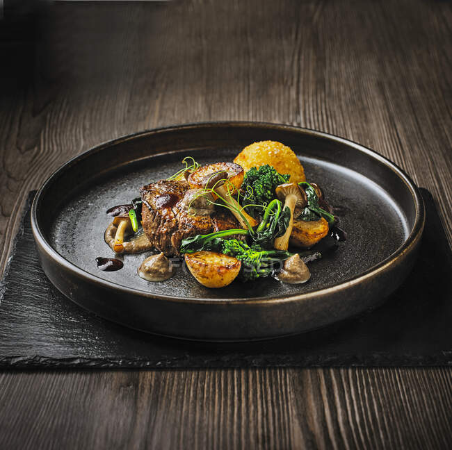 Rindfleisch mit Kartoffeln, Brokkoli und Pilzen auf Teller serviert — Stockfoto