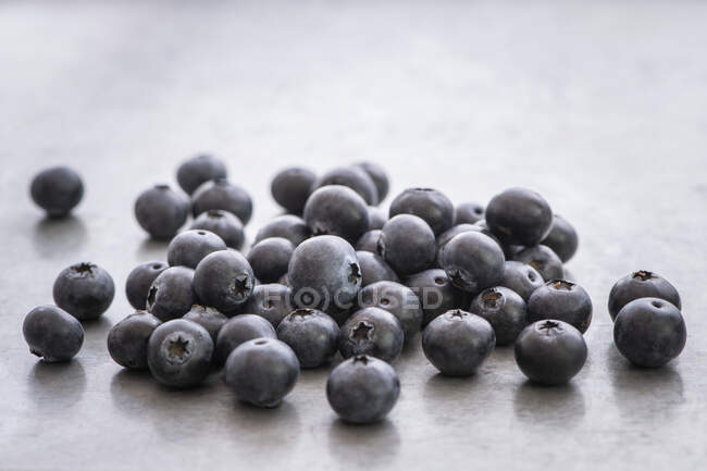 Fresh blueberries on stone surface with reflection — Stock Photo