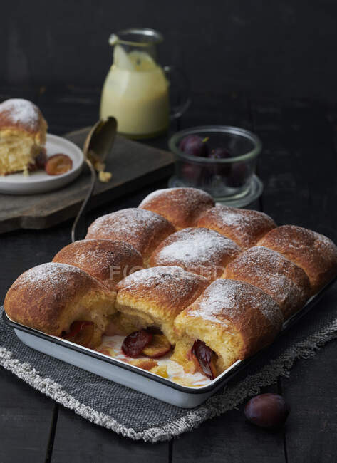 Bread rolls with plum filling and sugar powder in tin — Stock Photo