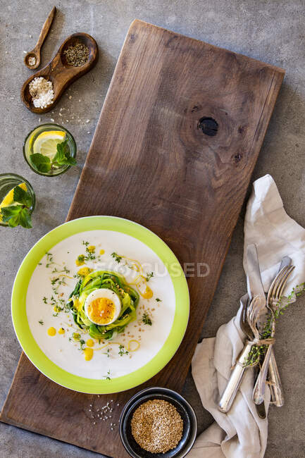 Boiled egg in nest of herbs with lemon dressing, sesame seeds and cress — Stock Photo