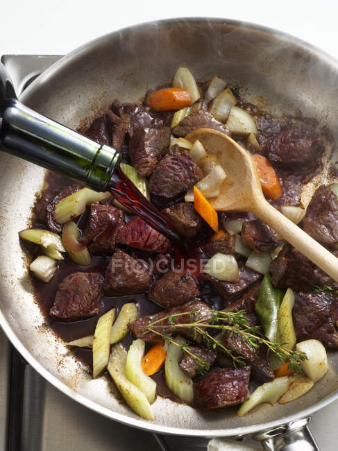 Beef ragout being deglazed with red wine — Stock Photo