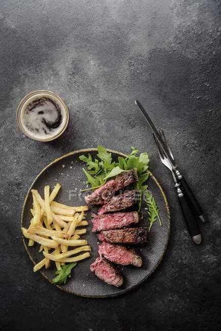 Grilled t-bone steak with rocket and chips — Stock Photo