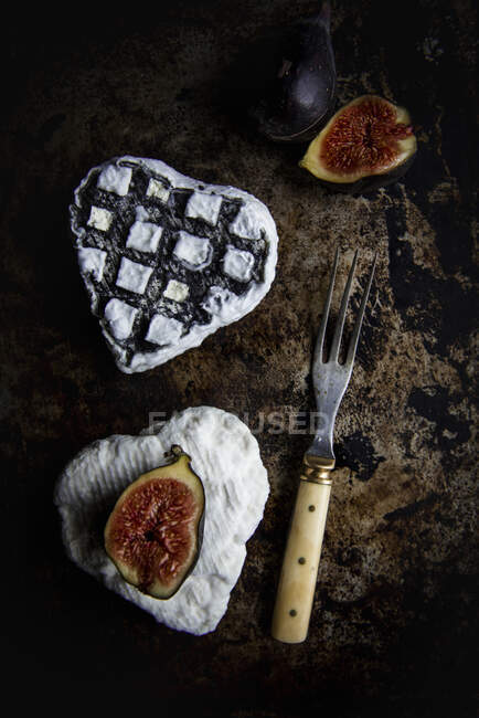 Formaggio di capra a forma di cuore e fichi freschi su superficie rustica con forchetta vintage — Foto stock