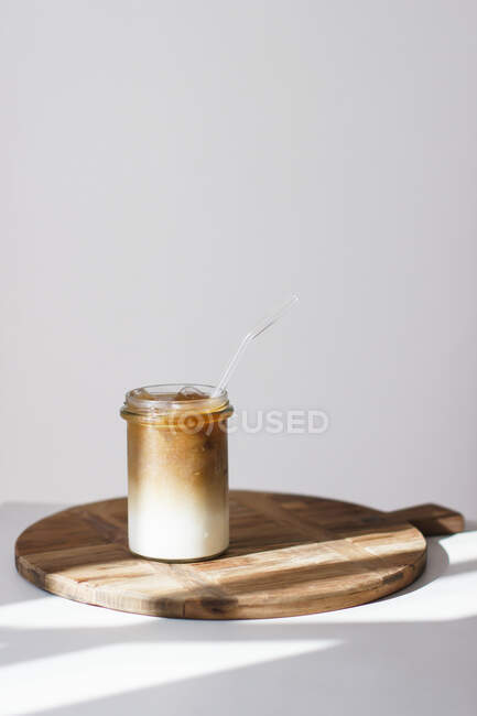 Café gelado em uma tábua de madeira contra um fundo branco — Fotografia de Stock