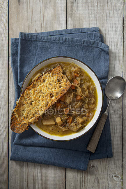 Лук и овощной суп с хлебом из запеченного сыра — стоковое фото