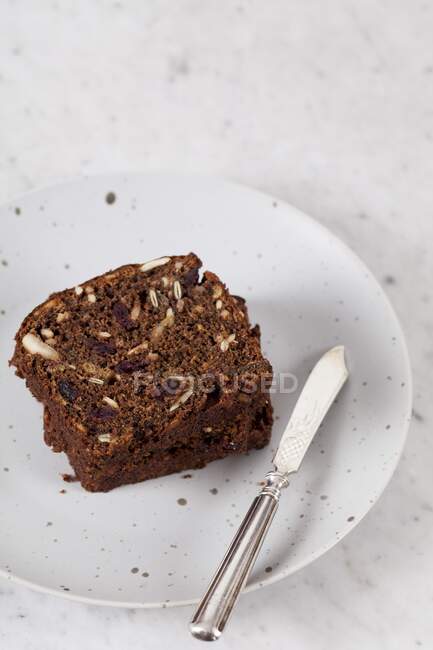Two slices of banana bread with sunflower seeds, pumpkin seeds, cranberries, apple butter and walnut flour — Stock Photo