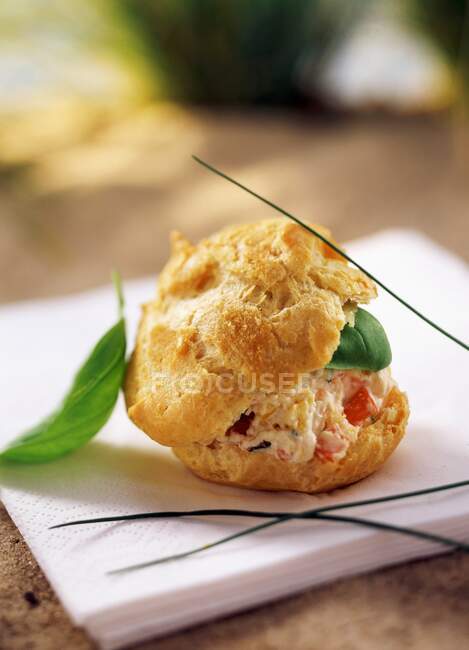 A single choux pastry in a beach setting — Stock Photo