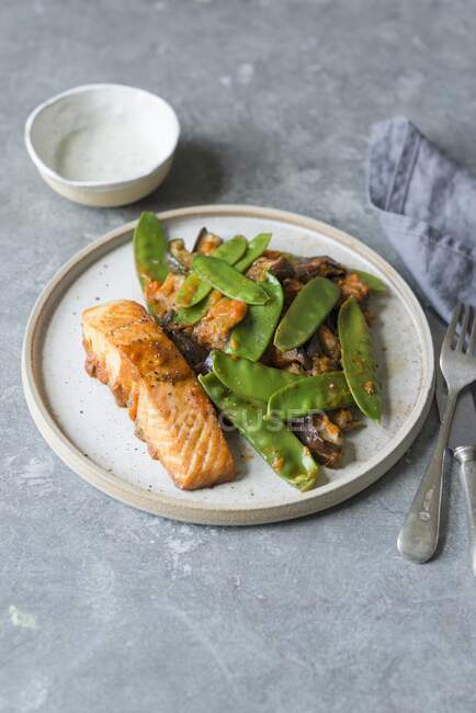 Roasted salmon fillet with roasted courgette, aubergine and green peas — Stock Photo