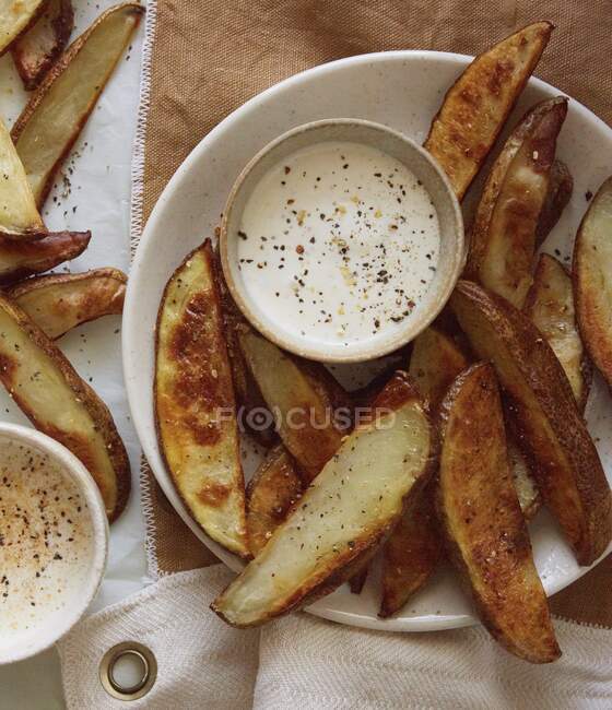 Patatas fritas con salsas y condimentos - foto de stock