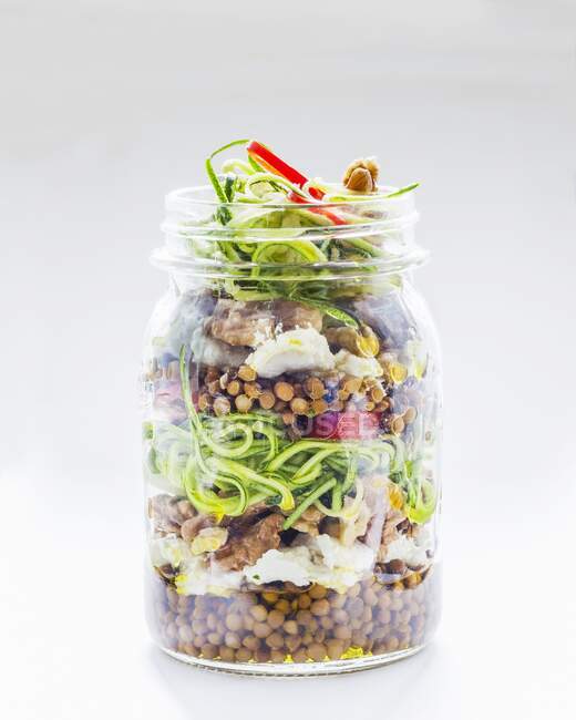 Vegetable salad with lentils and courgette in a glass jar — Stock Photo