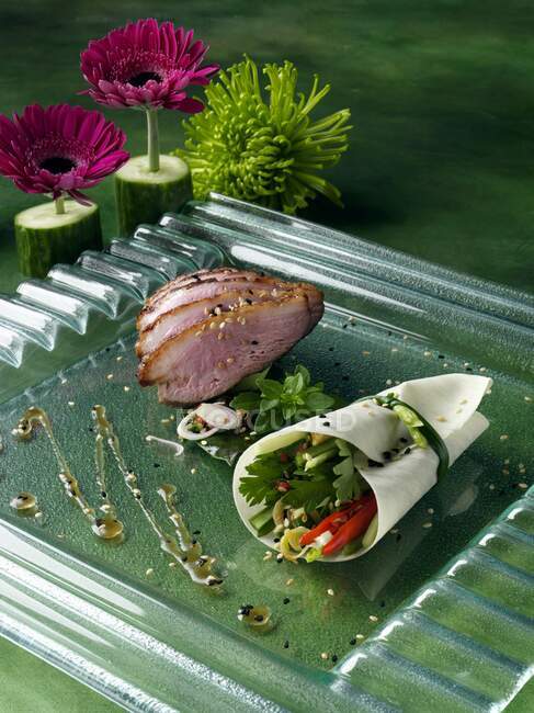 Duck, restaurant serving with gerbera flowers — Stock Photo
