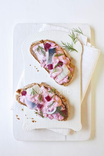 Herring salad with beetroot and dill on bread — Stock Photo