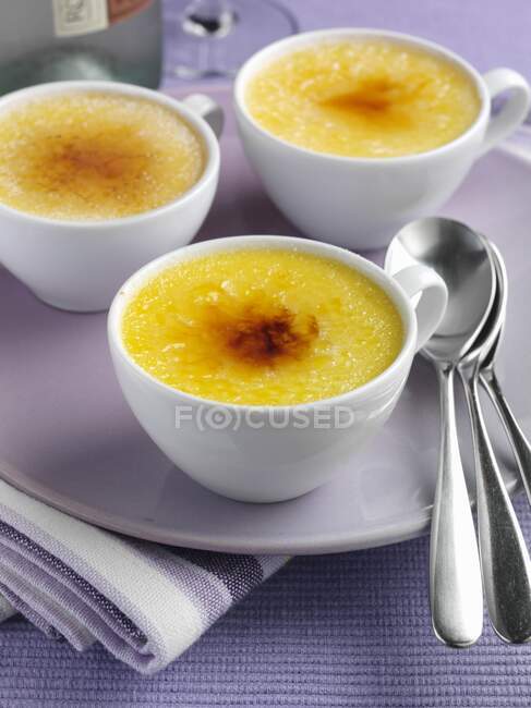 Three white cups of Creme brulee — Stock Photo