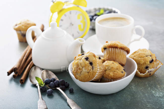 Blueberry muffins in a bowl with a cup of tea for breakfast — Stock Photo