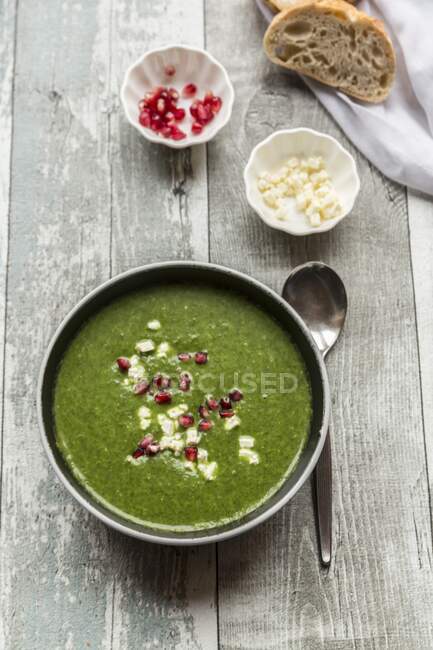 Зелений капустяний суп з насінням гранату та кубиками фети — стокове фото