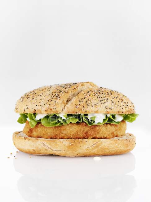 Una hamburguesa de pollo con mayonesa y ensalada - foto de stock