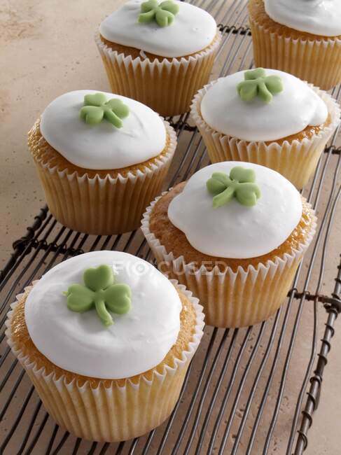 Cupcakes com trevo verde no topo da cobertura branca — Fotografia de Stock