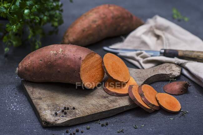 Batata doce, cortada em fatias, numa tábua de cortar — Fotografia de Stock