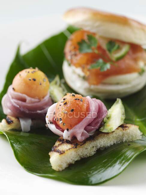 Smoked salmon roll with melon and parma ham canapes — Stock Photo