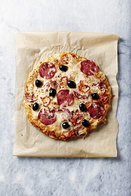 Rustic pizza with spicy salami, cheese and red chili peppers — Stock Photo