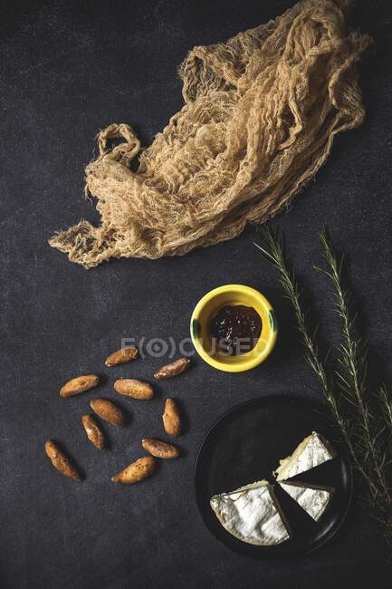 Camembert cheese with breadsticks and jam on old table with napkin — Stock Photo