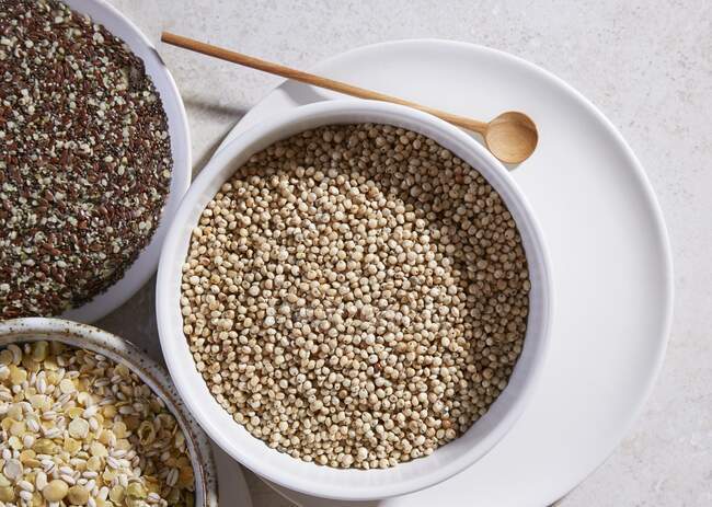 Sorghum, linseed and lentils in bowls — Stock Photo