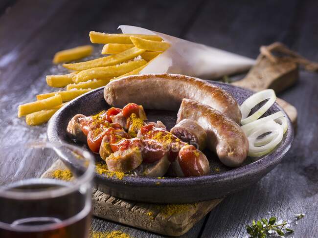 Saucisses au curry avec frites et rondelles d'oignon — Photo de stock