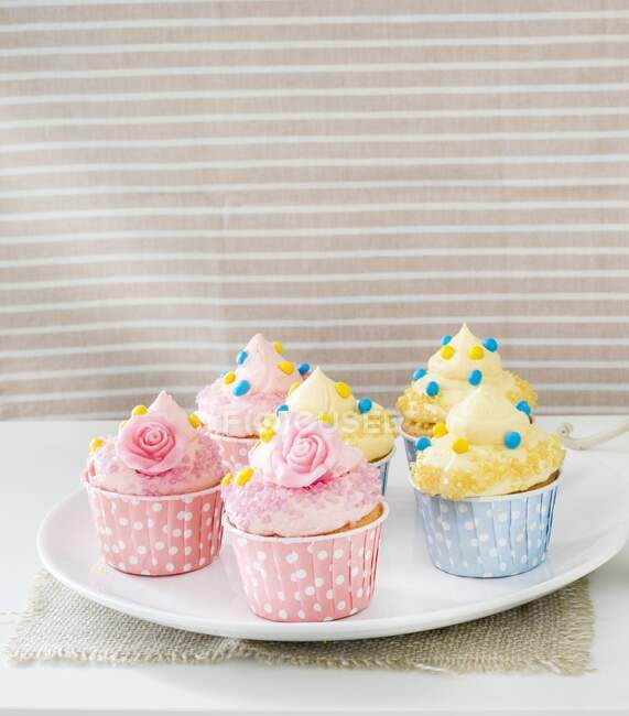 Cupcakes de creme rosa e amarelo decorados — Fotografia de Stock